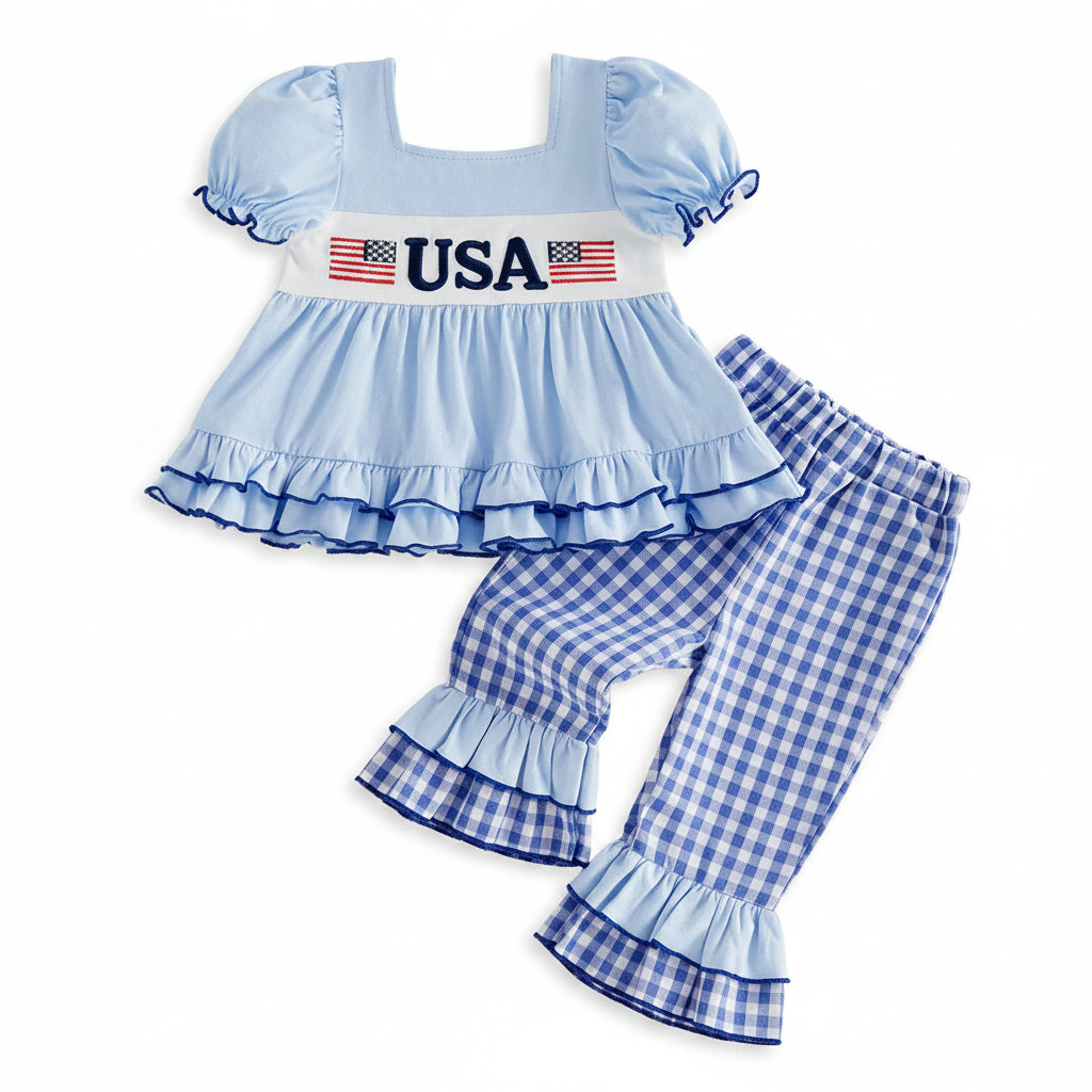 Children's outfit with blue top and checkered pants on a beige background