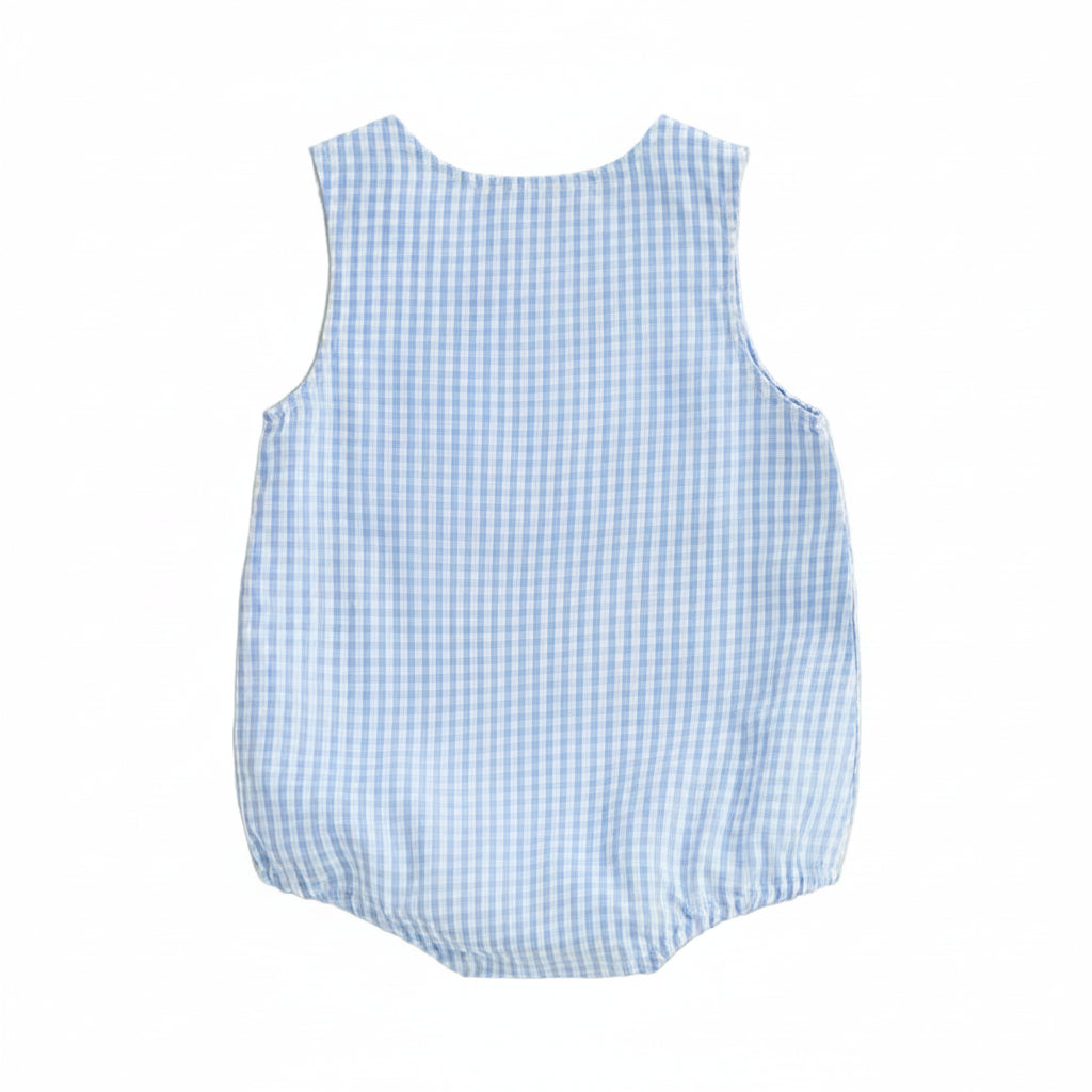 Blue checkered baby romper on a beige background with decorative elements.