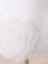 Close-up of a white fabric lampshade featuring a large layered rosette flower applique on the front.