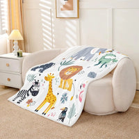 Jungle Rumble double-sided children's blanket, 100% polyester fleece, safari animals on white, draped over beige sofa.