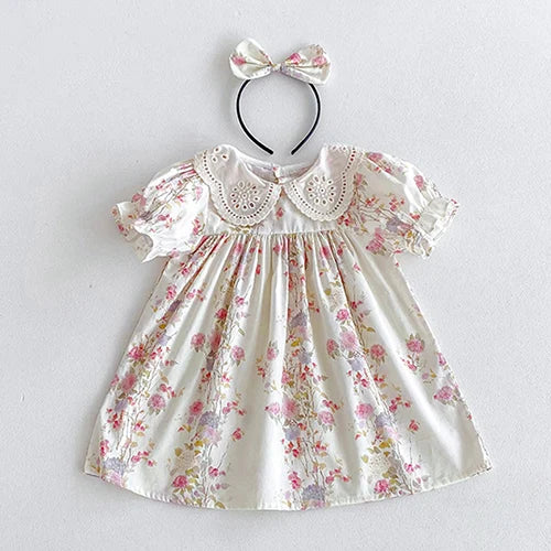 Vintage Outfits for children, presenting a lovely floral dress with a classic collar, accompanied by a matching hair accessory.