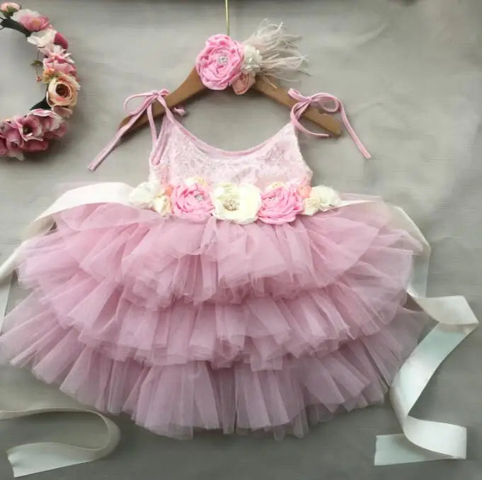 Cecilia vintage tiered pink tulle dress with floral belt and headband on a hanger.