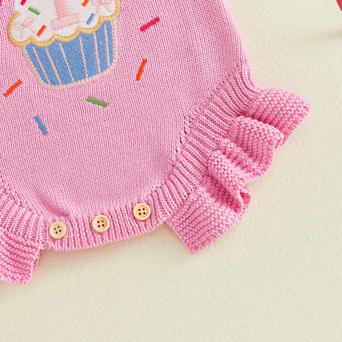 Pink knitted baby romper with cupcake embroidery and buttoned hem.