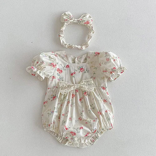 Vintage Outfits for infants featuring a cream floral romper adorned with a bow and a matching headband from The Palm Beach Baby.
