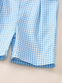 Blue and white gingham fabric detail of a sleeveless baby romper with button closures for infants and toddlers.