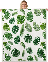 Jungle Rumble double-sided children's blanket with tropical leaf print on white, held by smiling person.