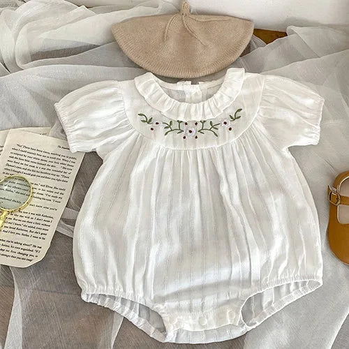Spring Frills Baby Bubbles in classic white with delicate embroidery and ruffles, perfect for your little one's spring wardrobe.