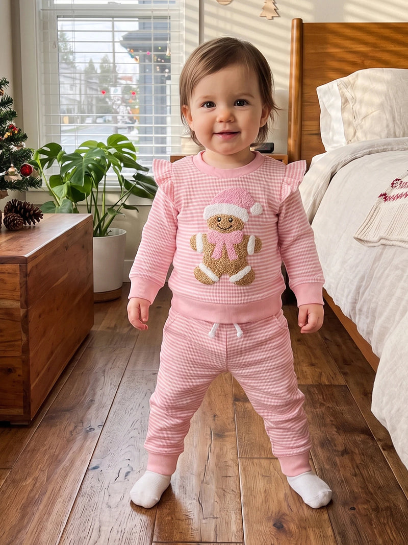 Toddler girl wearing pink striped waffle knit 2-piece set with long sleeve gingerbread embroidery pullover and matching pants.