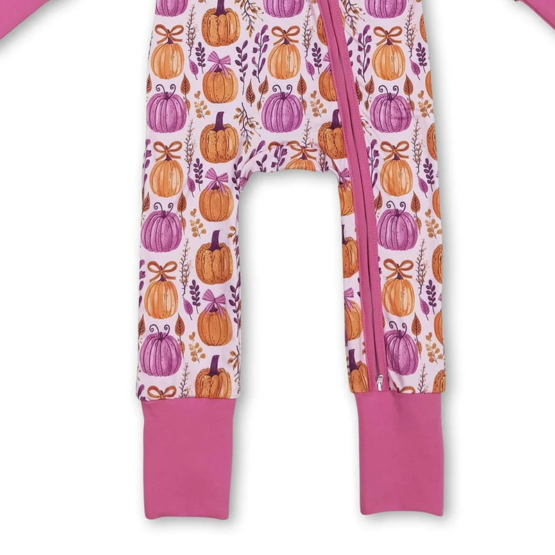 Detail view of the legs of the 'Pumpkins and Flowers' romper zippered front in hot pink, highlighting its vibrant design.