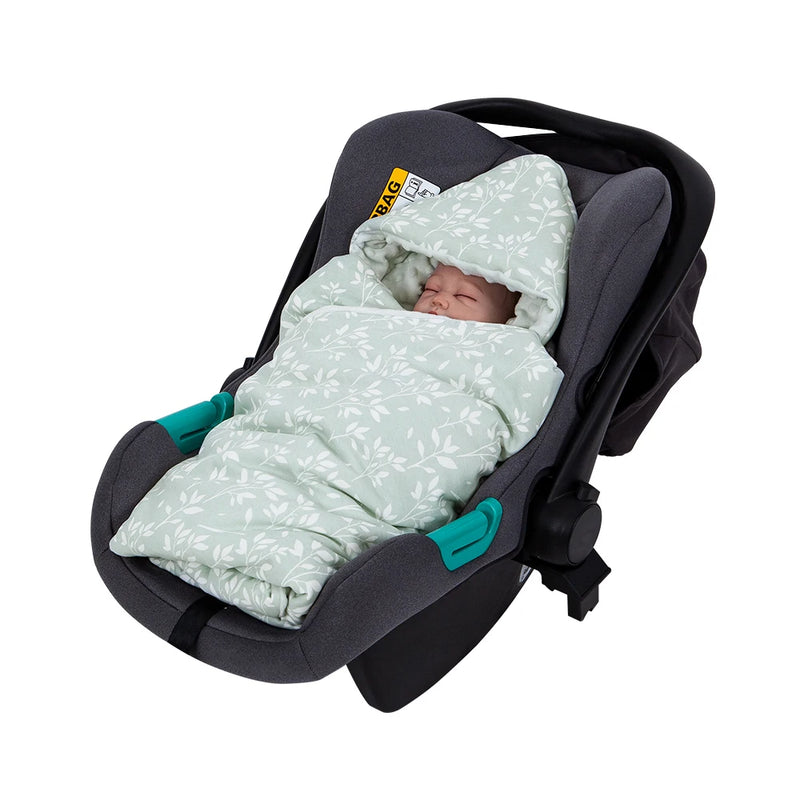 A peaceful baby wrapped in an Adorable Ultra-Soft Baby Swaddle Blanket, featuring a floral pattern, securely nestled in a car seat for cozy outings.