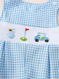 Blue and white gingham baby romper with embroidered golf bag, flag, and cart on white panel. Sleeveless button closure design.