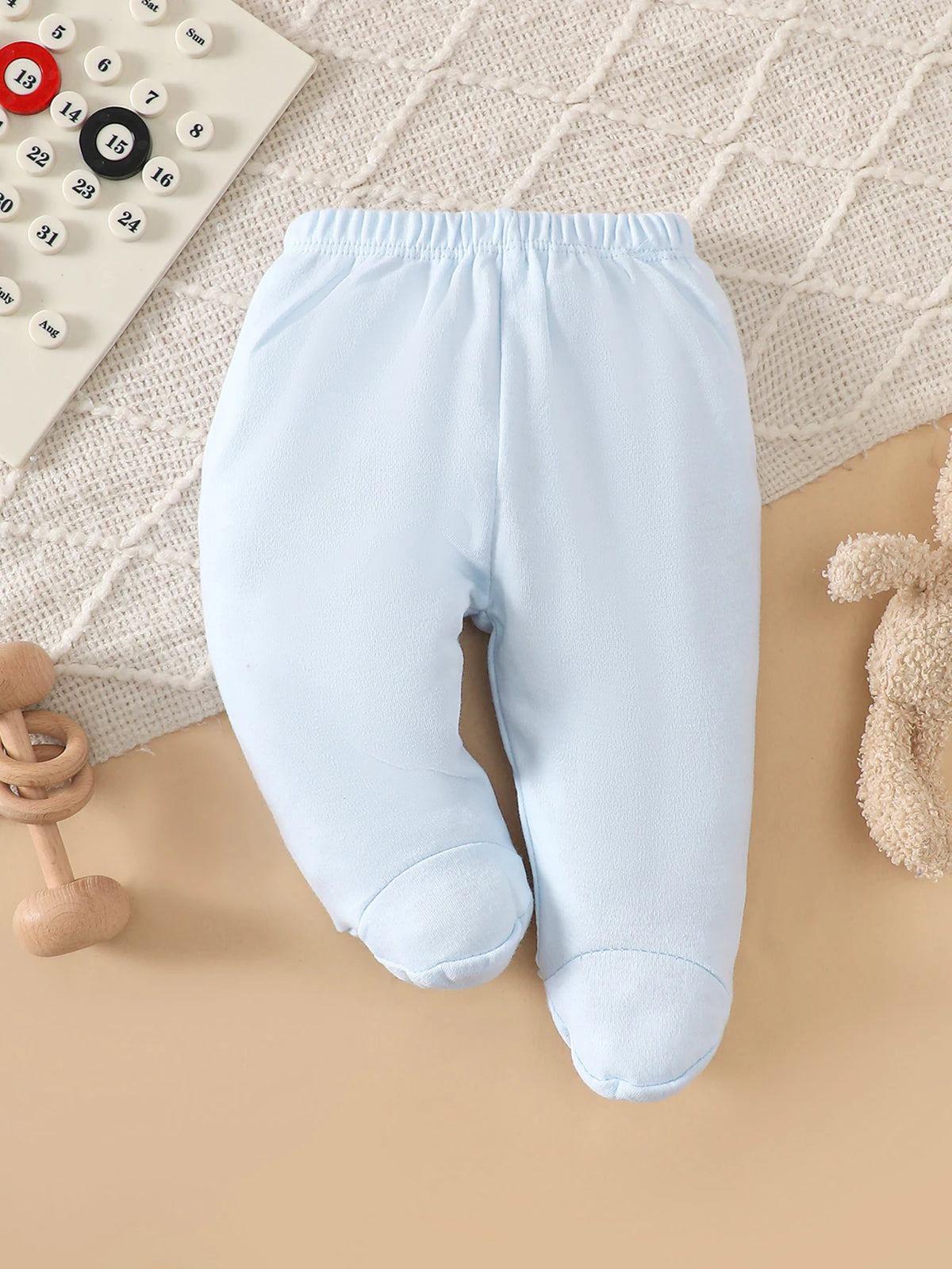 Light blue cotton baby footed pants from an 8-piece layette set.