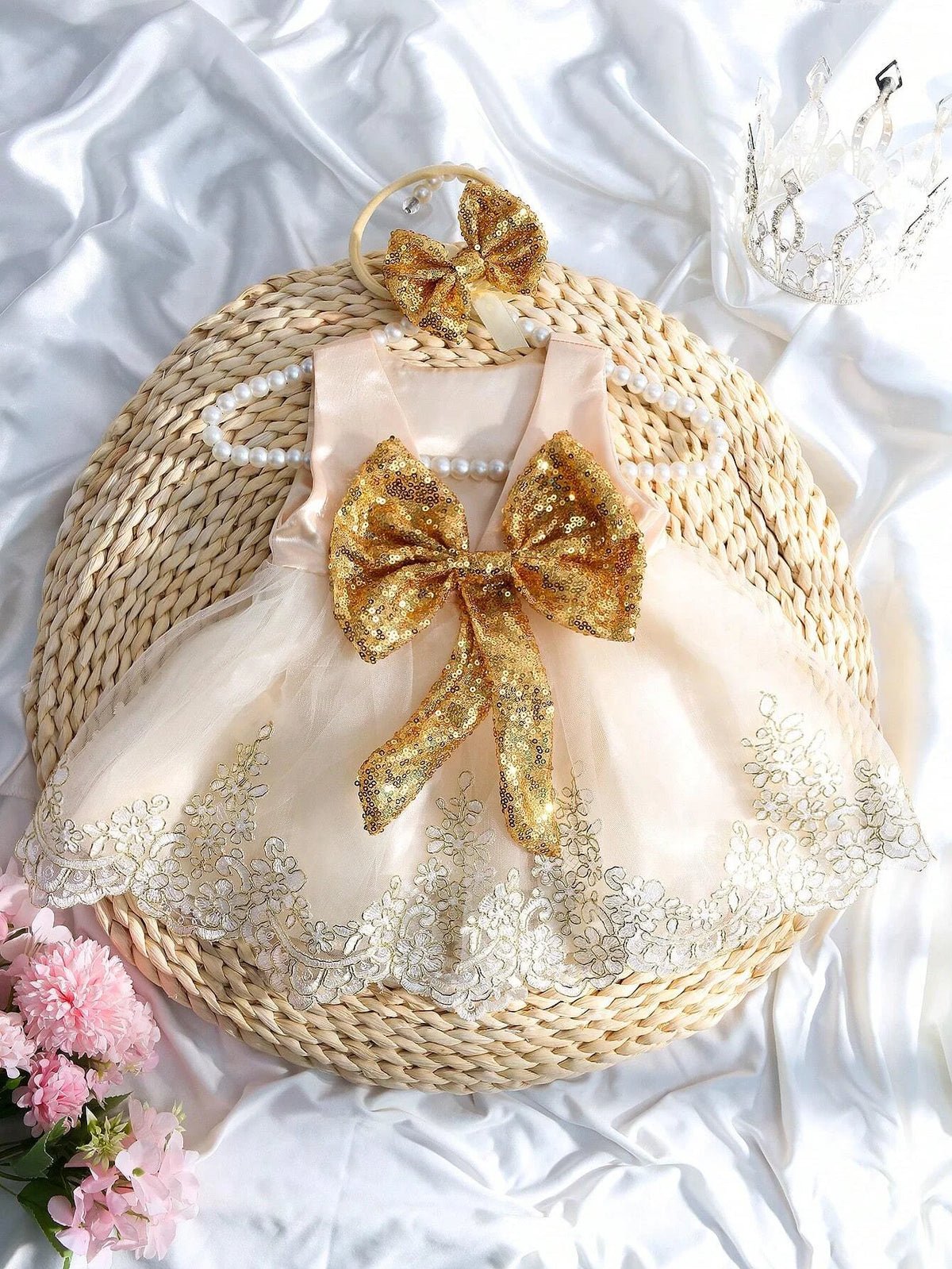 Infant sequined V-back dress with an oversized gold bow and matching headband, pink satin bodice, lace trim.