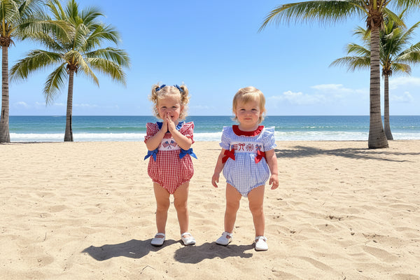 Two young girls in matching outfits standing on a gravel surface with decorative items in the background.