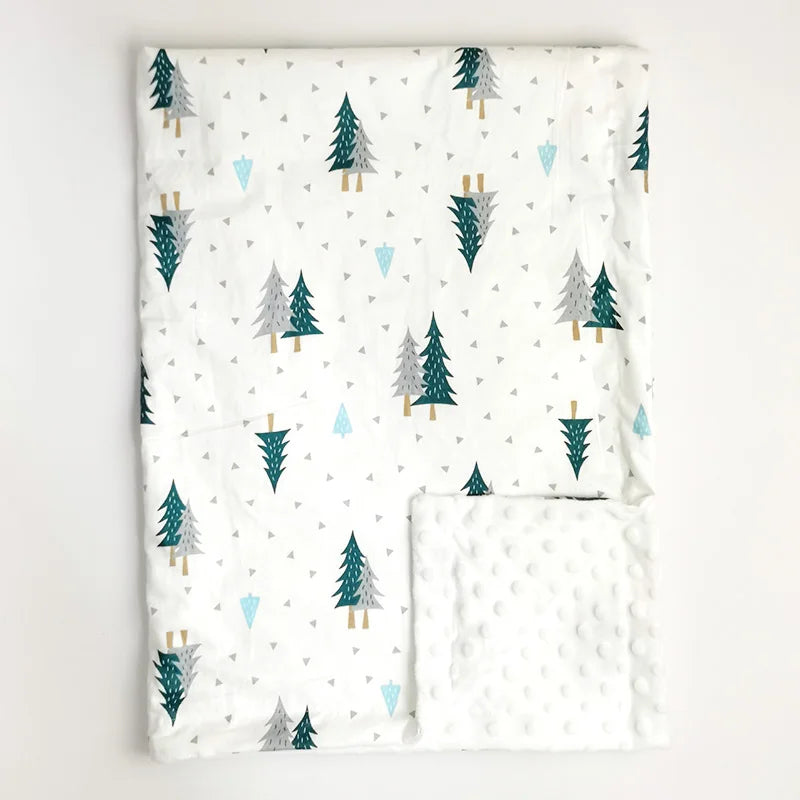 Soft white minky baby blanket featuring green pine trees and geometric triangles, with plush dotted texture for comfort.