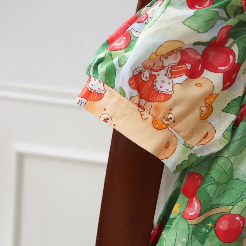Detail of the sleeve of A Very Cherry Day Embroidered Dress, showcasing the colorful cherry print dress design with adorable characters and cherries.