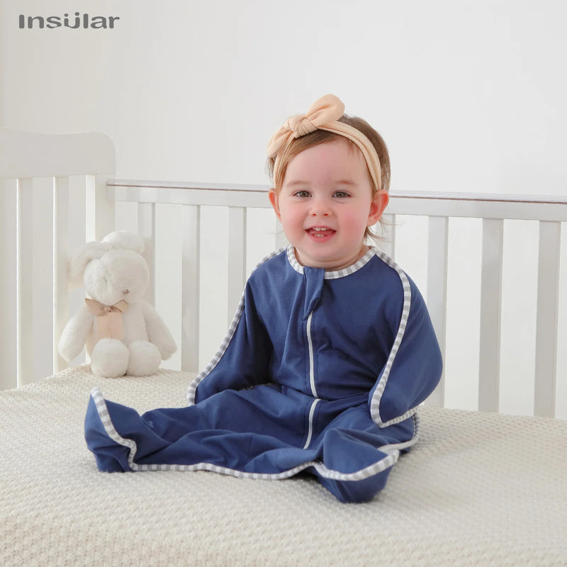 Happy baby in a Cozy Cotton Anti-Kick Calming Baby Sleeping Sack, showcasing comfort and style while sitting in a crib.