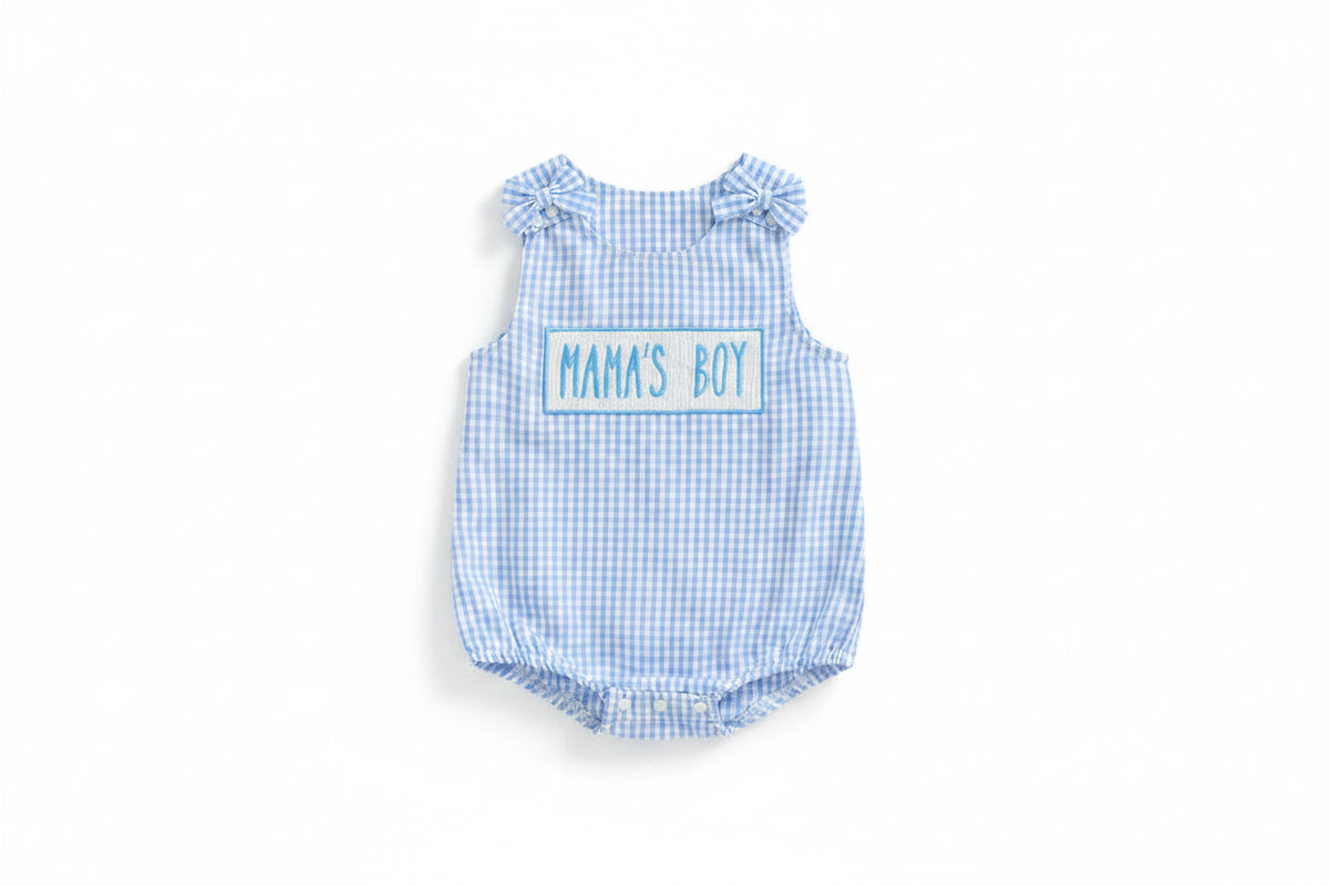 Blue checkered baby romper with 'MAMA'S BOY' text on a beige background