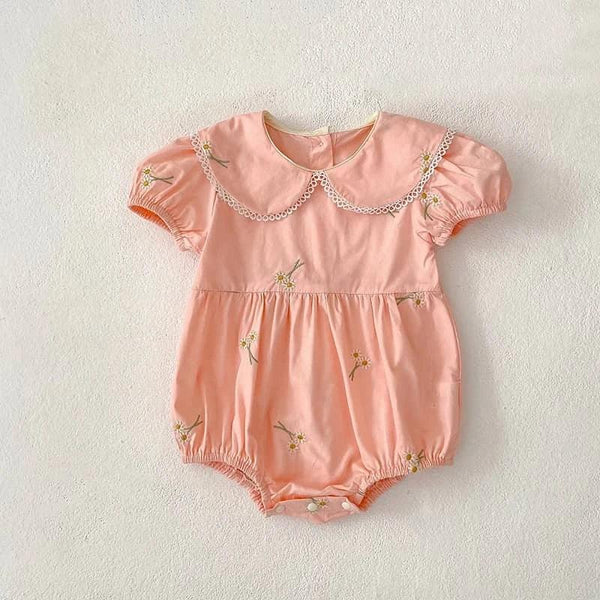Pink embroidered baby bubble romper with floral designs and lace-trimmed collar for infants