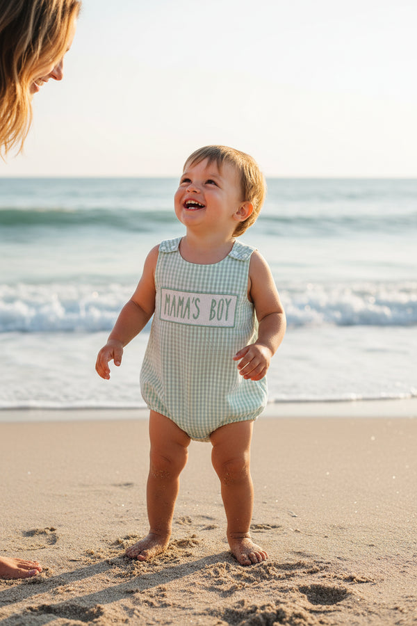 Green checkered baby romper with 'MAMA'S BOY' text on a white background