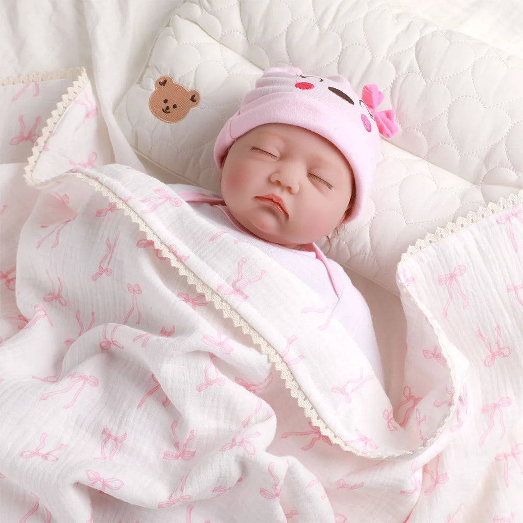 Soft Cotton Baby Blanket with Lace featuring a cute design, wrapping a sleeping baby doll in a cozy setting.