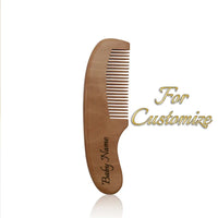 Wooden baby comb with customizable name on the handle.