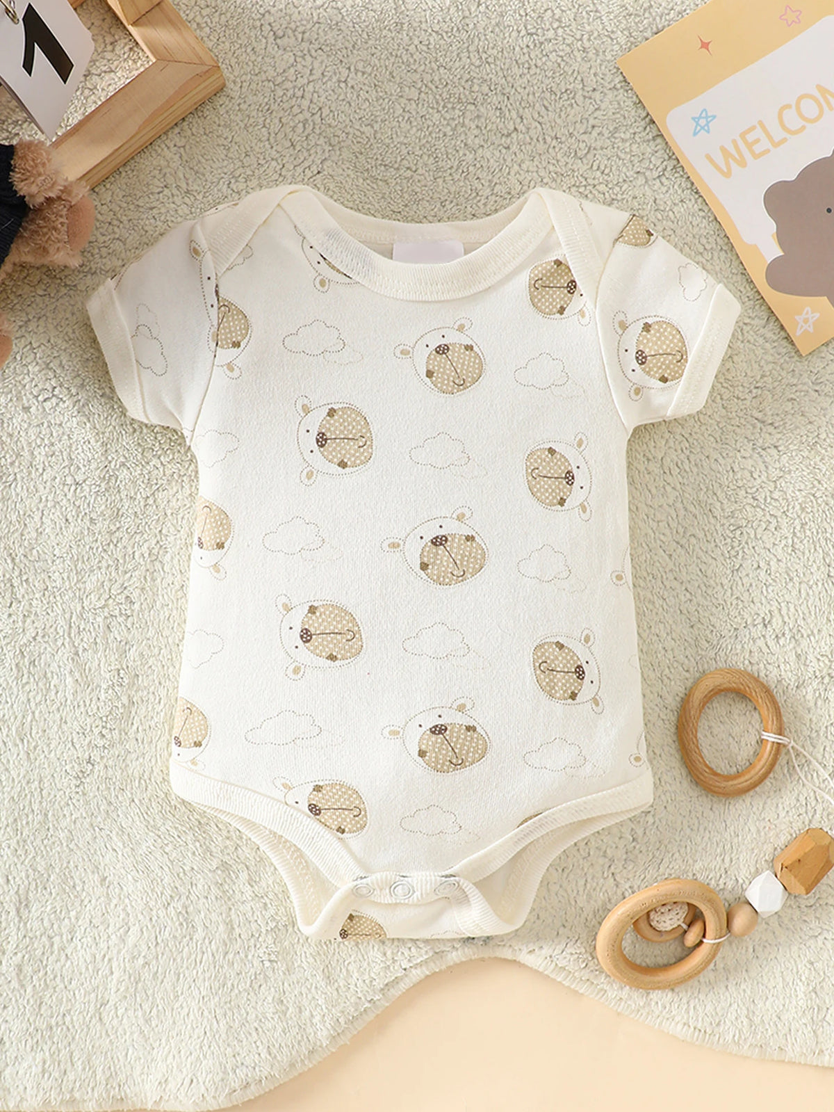 Little Bear beige 8-piece newborn romper set in white cotton with bear faces and clouds; snaps at the legs.