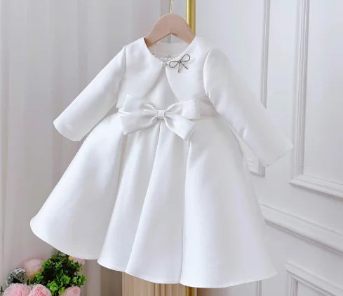 Patience Marie white satin girls' knee-length dress with waist bow and long sleeves for special occasions.