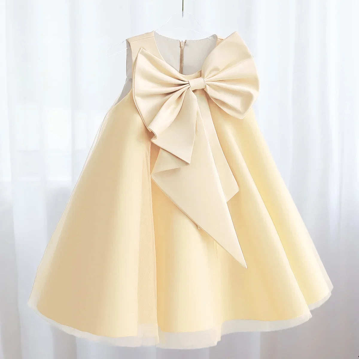 Cream-colored Sari-Elle dress with a large bow at the waist, elegant A-line party dress for girls aged 4–6.