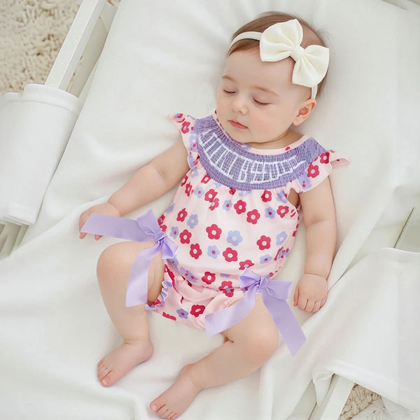 Floral romper for babies in pink with purple ruffle collar and lavender bows, newborn size