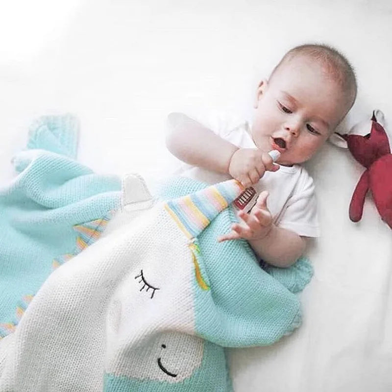 An innocent baby cuddled in a unicorn blanket made for comfort, part of the 'Sleepy Tight' cute animal blankets collection.