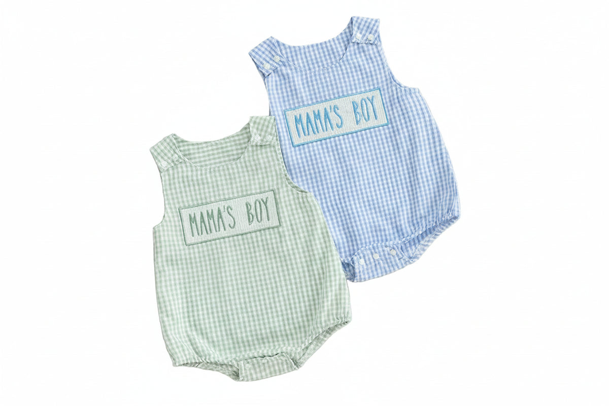Two baby rompers, one green and one blue, with 'Mama's Boy' text on a beige background.