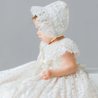 Elegant ivory lace gown and matching bonnet set for infants. Features satin bow and floral appliques, perfect for baptism, weddings, and special occasions.