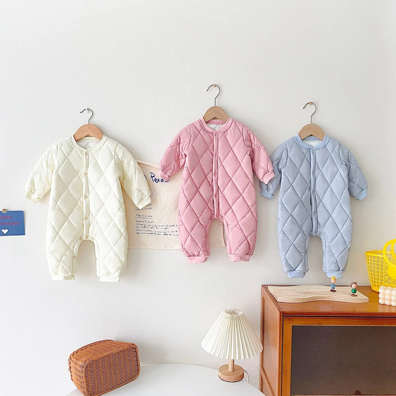 Three baby quilted rompers in Sweet Cream, Princess Pink, and Precious Baby Blue arranged neatly, showcasing their warmth and style.