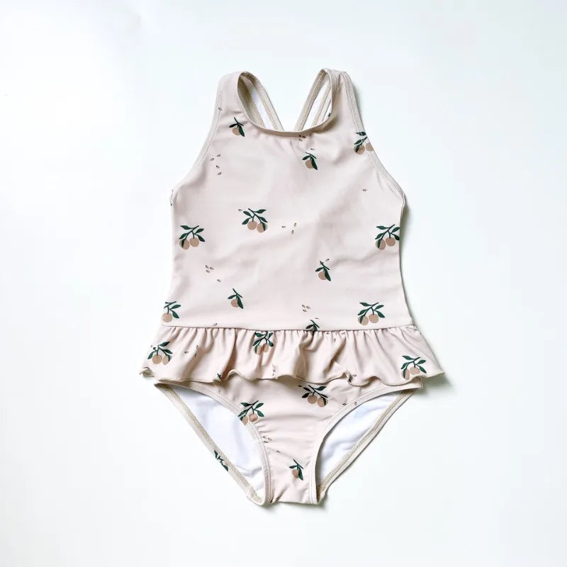 Frilly peach-printed sun-protective girls' one-piece swimsuit with crisscross back and ruffle hem.