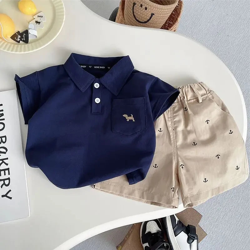 Close-up of the Preppy 'Daron' 2 PC Kids Khaki Shorts Set showcasing the navy polo and khaki shorts with anchor designs, ideal for stylish kids.