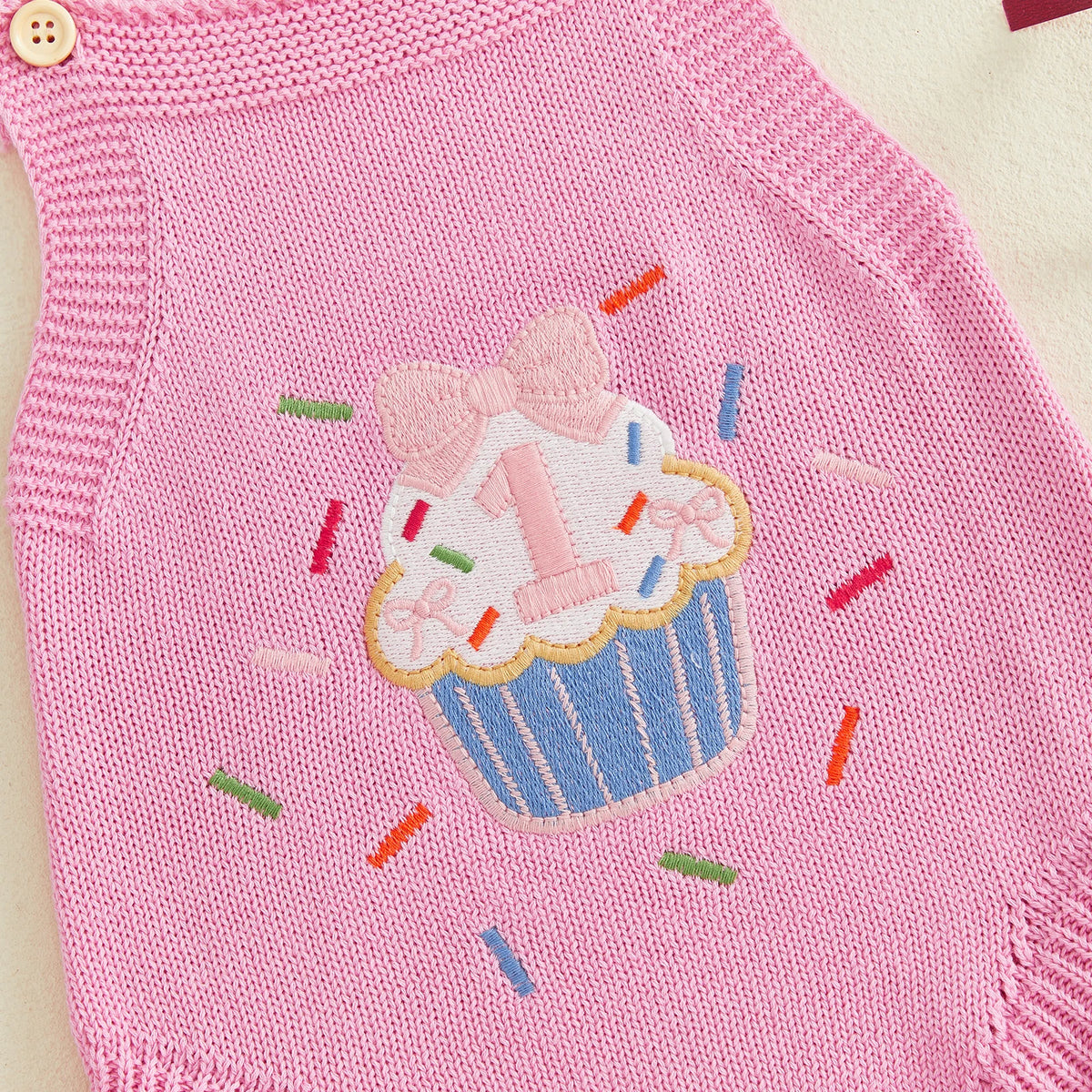Pink knit romper overalls with cupcake applique and colorful sprinkles.