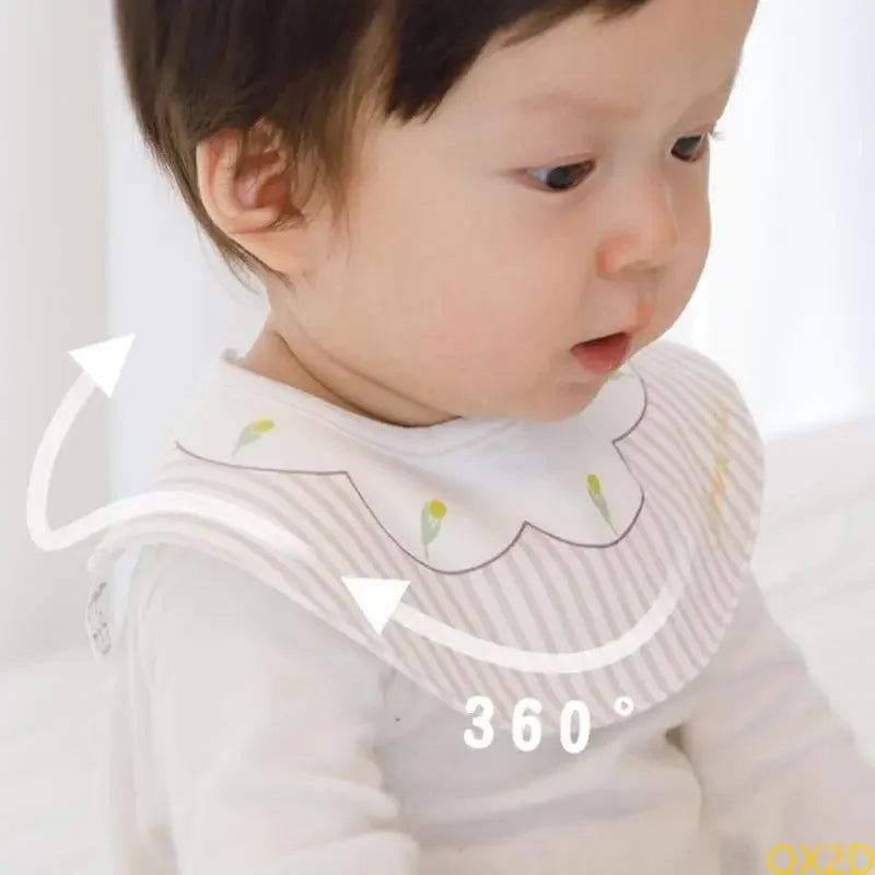 Embroidered waterproof baby bib with delicate floral design and snap closure for comfortable 360-degree fit during meal time.