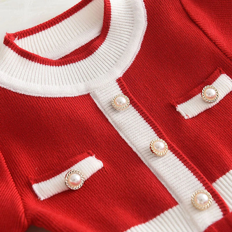 Close-up of the Chic Melinda Knit Dress in red, highlighting the delightful button details and stylish neckline.