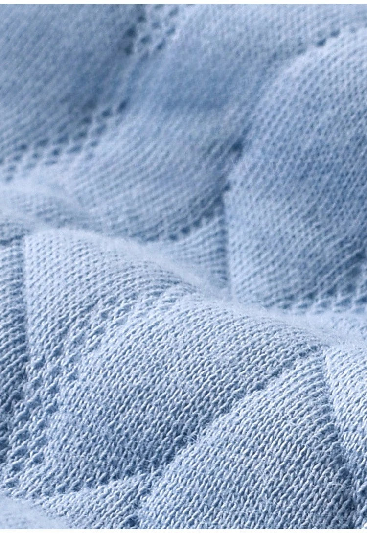 Detailed texture shot of the cozy quilted fabric of the blue Mr. Bear Quilted Baby Romper, emphasizing warmth and comfort.