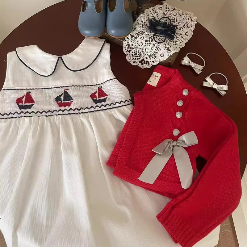 Little girl wearing the Set Sail Little Girl's Party Dress at a garden party, showcasing its nautical style.