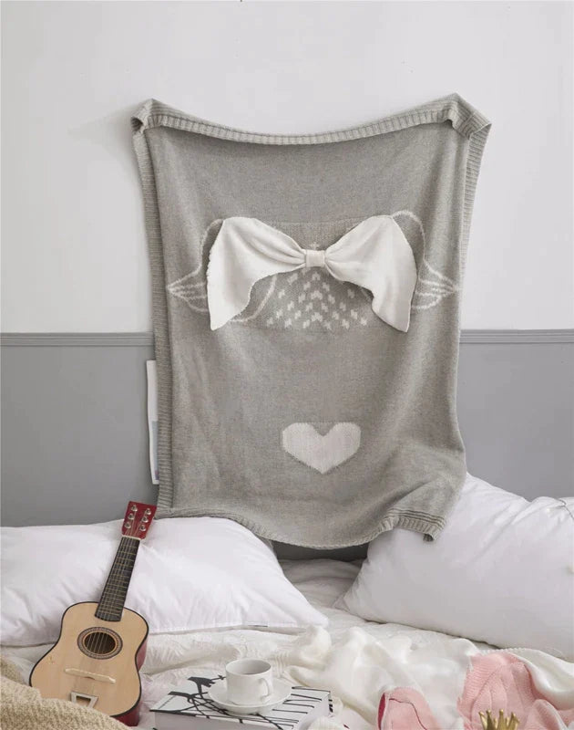 A cheerful baby sleeping under a unicorn blanket, highlighting the 'Sleepy Tight' cute animal blankets for kids.
