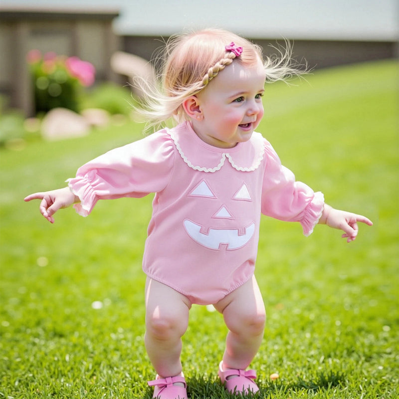 Toddler girl wearing the Pumpkin Polly Adorable Halloween Baby Outfit in Princess Pink while playing outside, showcasing the cute pumpkin design.