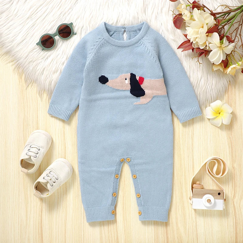 "Doxie Dashound" Embroidered Baby Sweater Romper in light blue displayed with cute accessory items.