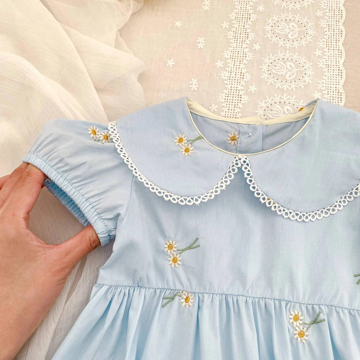 Light blue embroidered baby bubble romper with floral embroidery and lace collar detail