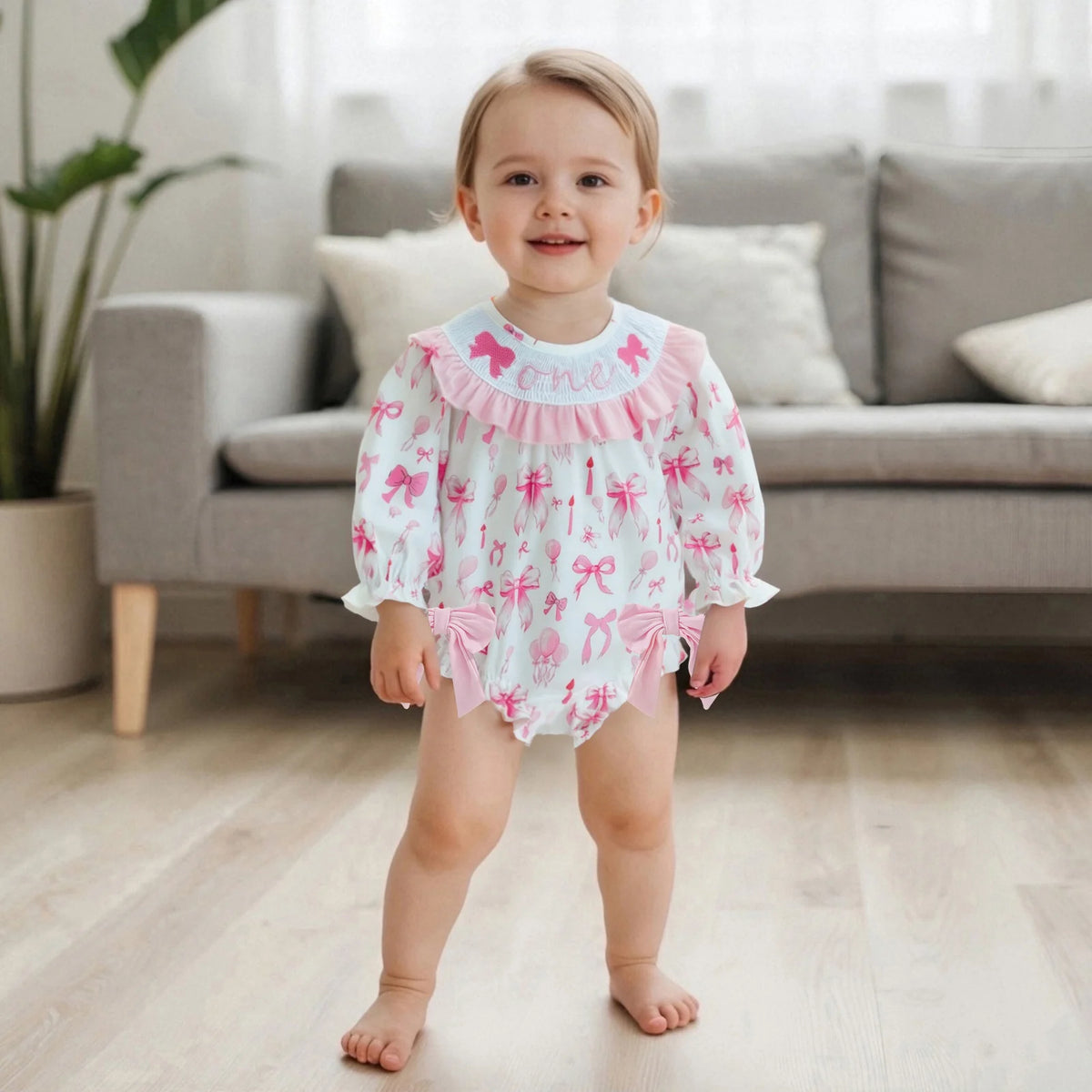 Child wearing a pink and white outfit with bows in a living room setting