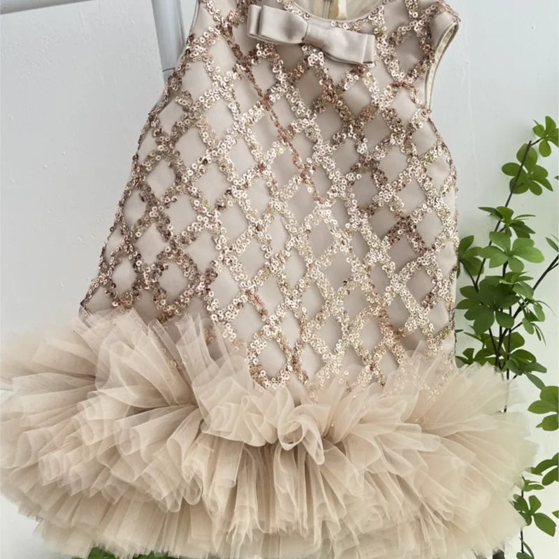 The elegant sequined dress for little girls, Isabella, displayed in beige with a fluffy tulle hem, perfect for special occasions.