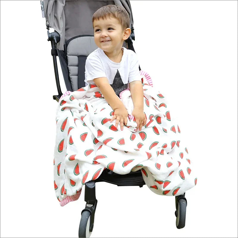 Newborn unisex two-layer bamboo cotton swaddle blanket with watermelon pattern in a stroller.