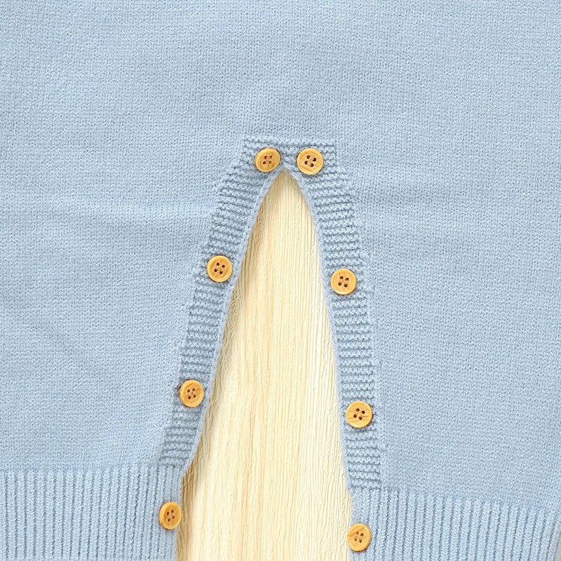 Button closure detail on the leg of the "Doxie Dashound" Embroidered Baby Sweater Romper.