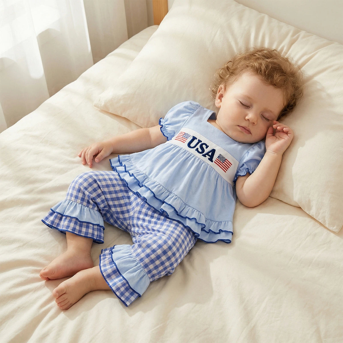 Child wearing a blue outfit with 'USA' print, lying on a beige couch.
